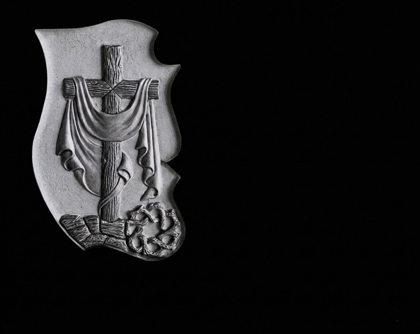 Lápida de nicho en granito negro con cruz y manto tallados. Diseño artesanal, personalizable y resistente para cementerios.