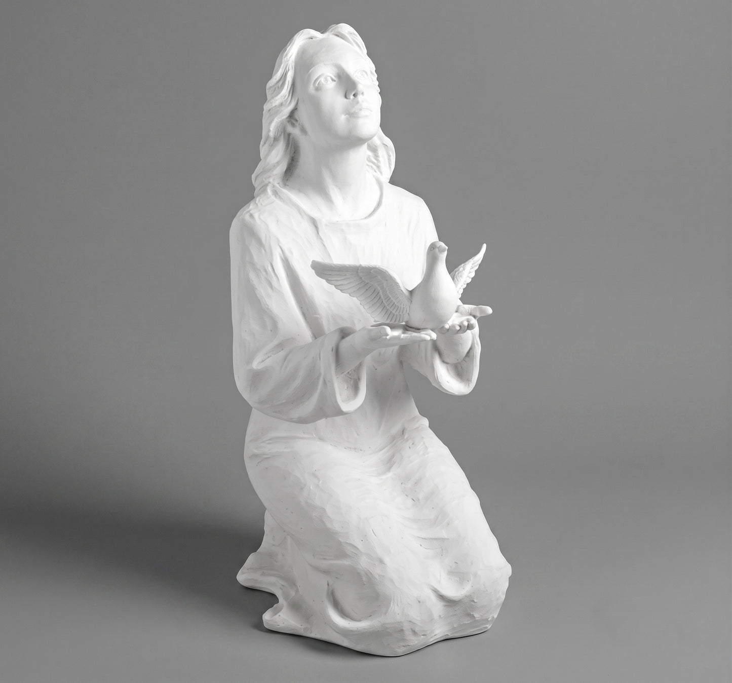 Elegante escultura de joven alzando una paloma (70 cm). Fabricada en mármol sintético de alta resistencia con fijación a suelo. Ref: MR 7478. Ideal para cementerios y jardines