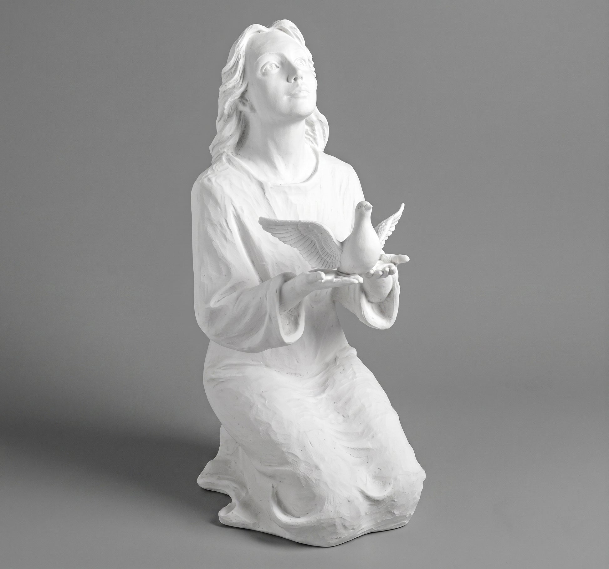 Elegante escultura de joven alzando una paloma (70 cm). Fabricada en mármol sintético de alta resistencia con fijación a suelo. Ref: MR 7478. Ideal para cementerios y jardines
