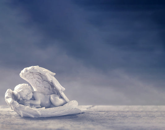 Lápida con imagen de angelito durmiendo sobre su ala, diseño emotivo que simboliza paz, protección y recuerdo eterno