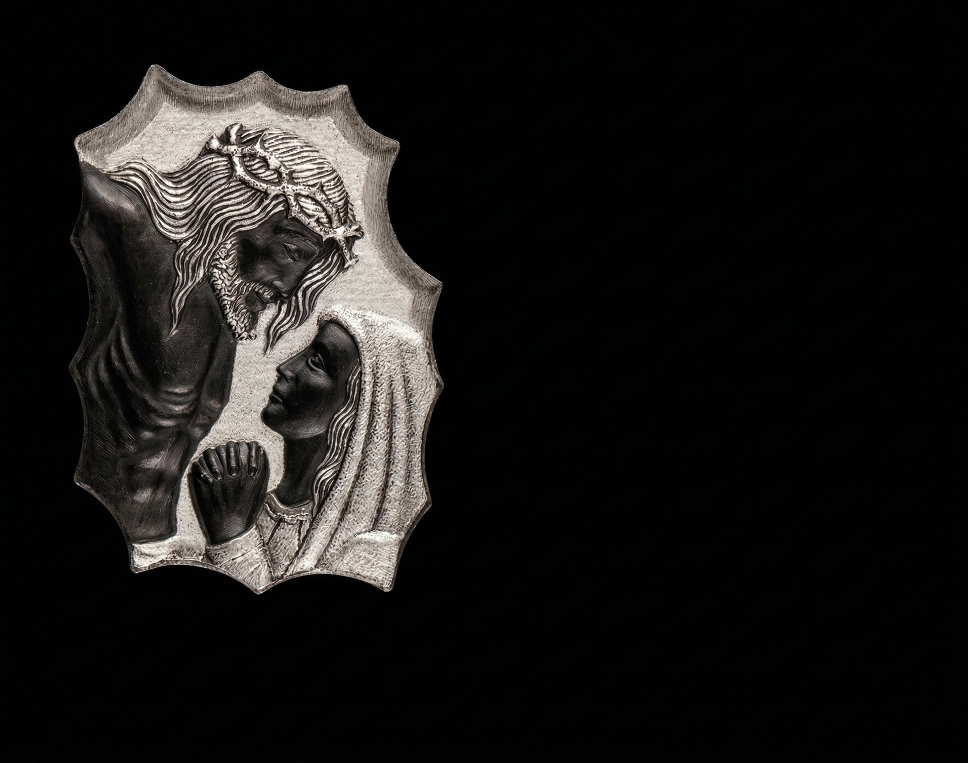 Lápida de nicho en granito negro con detalle de la Piedad tallado. Trabajo artesanal, gran durabilidad y acabado elegante para cementerios.