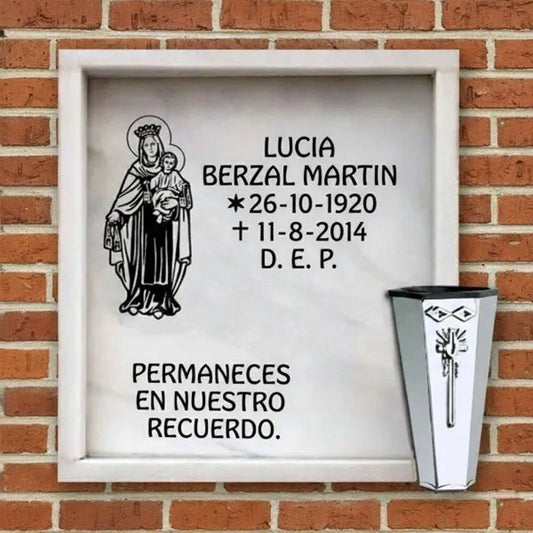 Lápida de columbario en mármol con Virgen del Carmen grabada y jarrón de acero inoxidable, con inscripción conmemorativa